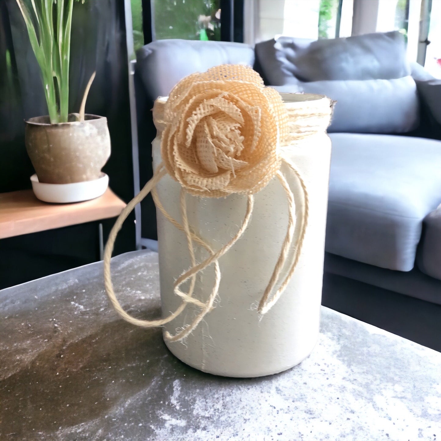 Deko Glas / Windlicht ist stilvolle Dekoration, weiß, mit Juteblume verziert.