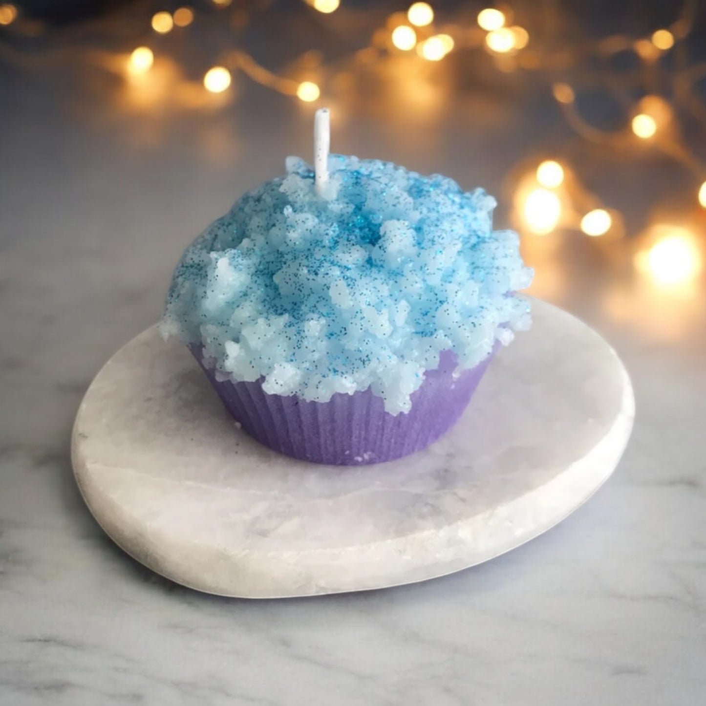Handgefertigte Muffin-Kerze in Blau mit weißem Wachs-Topping, inszeniert als stilvolle Deko oder originelles Geschenk für besondere Anlässe.